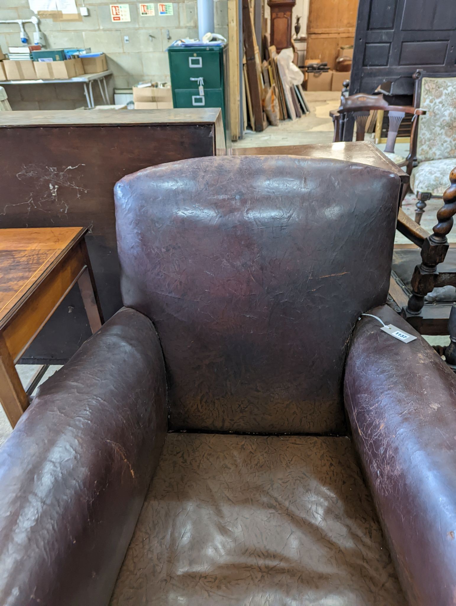 A studded brown leather club armchair, width 86cm, depth 81cm, height 90cm